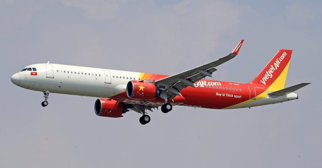 VietJet Air Airbus A321 captured mid-flight with landing gear deployed.