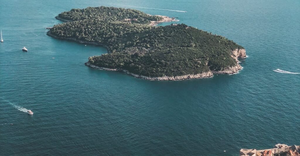 A breathtaking aerial view of a lush island and vibrant coastal city under a bright sky.