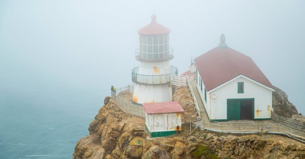 A misty view of the historic Point Reyes Lighthouse on the foggy California coast.