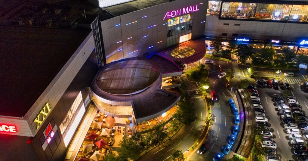 Illuminated aerial view of Aeon Mall in Banten, Indonesia, featuring a bustling parking lot at night.