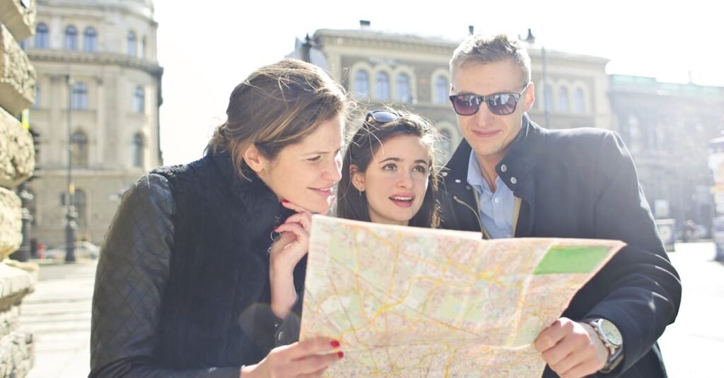 Three tourists exploring a city using a map under bright daylight, enjoying their travel journey.